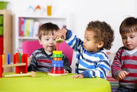 images (1) Two young children playing with a toy tower.